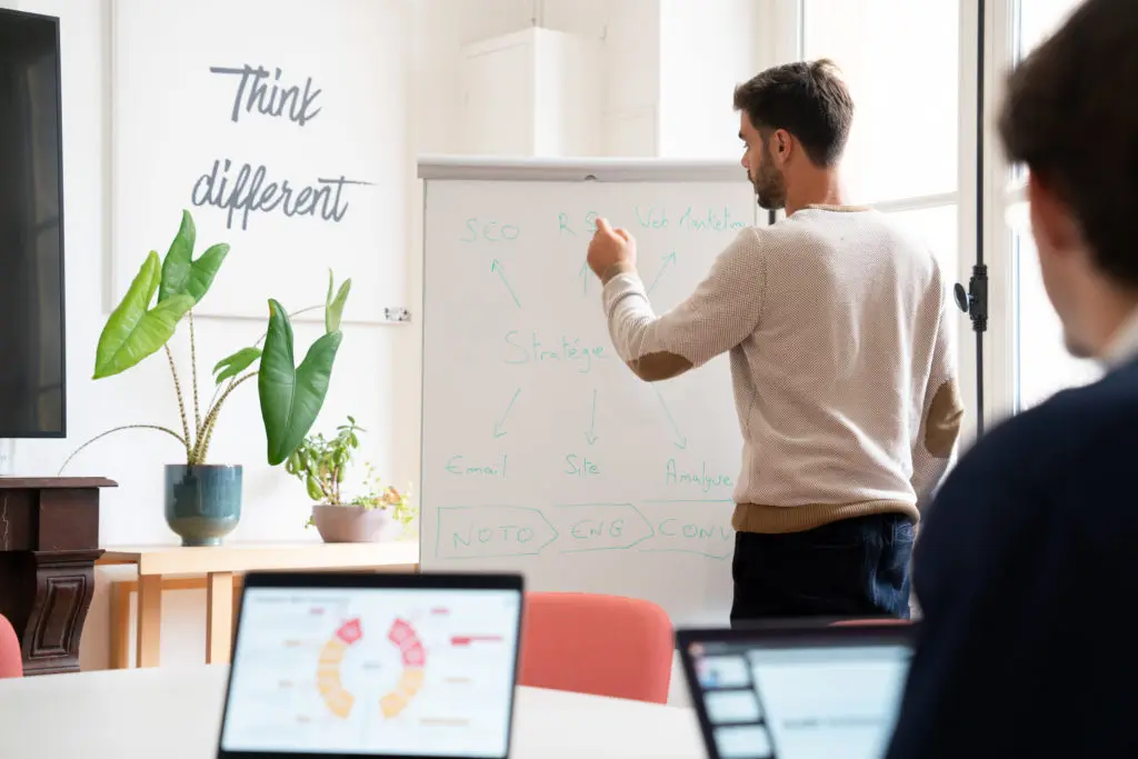 Personne donnant une conférence sur les stratégies SEO, avec un public attentif, abordant l'importance de l'UX, de l'éco-conception et de l'expérience utilisateur pour une navigation numérique mémorable.