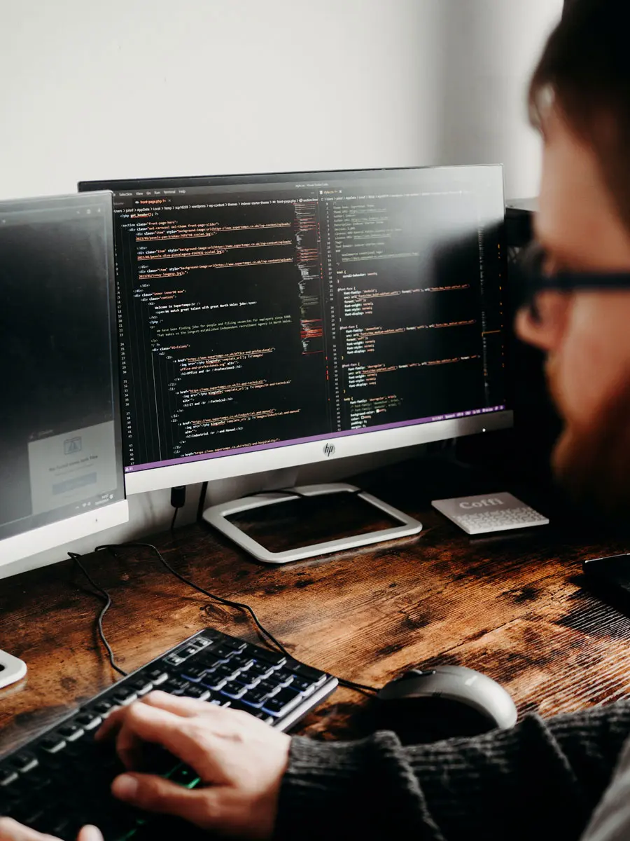 Un homme en train de coder, vu de dos, représentant le processus d'éco-conception web d'Digitik, une agence à Bordeaux engagée dans le développement de projets numériques écoresponsables.