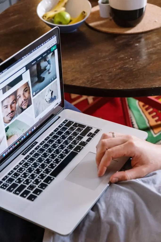 Main posée sur un ordinateur, regardant un site web conçu par lui, représentant le processus de création ou de refonte de sites internet professionnels.
