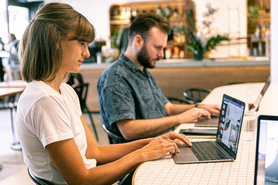 Deux personnes concentrées sur un ordinateur, travaillant ensemble sur le design et le graphisme, démontrant l'engagement d'Ethiko dans la création de contenus visuels de qualité pour ses projets